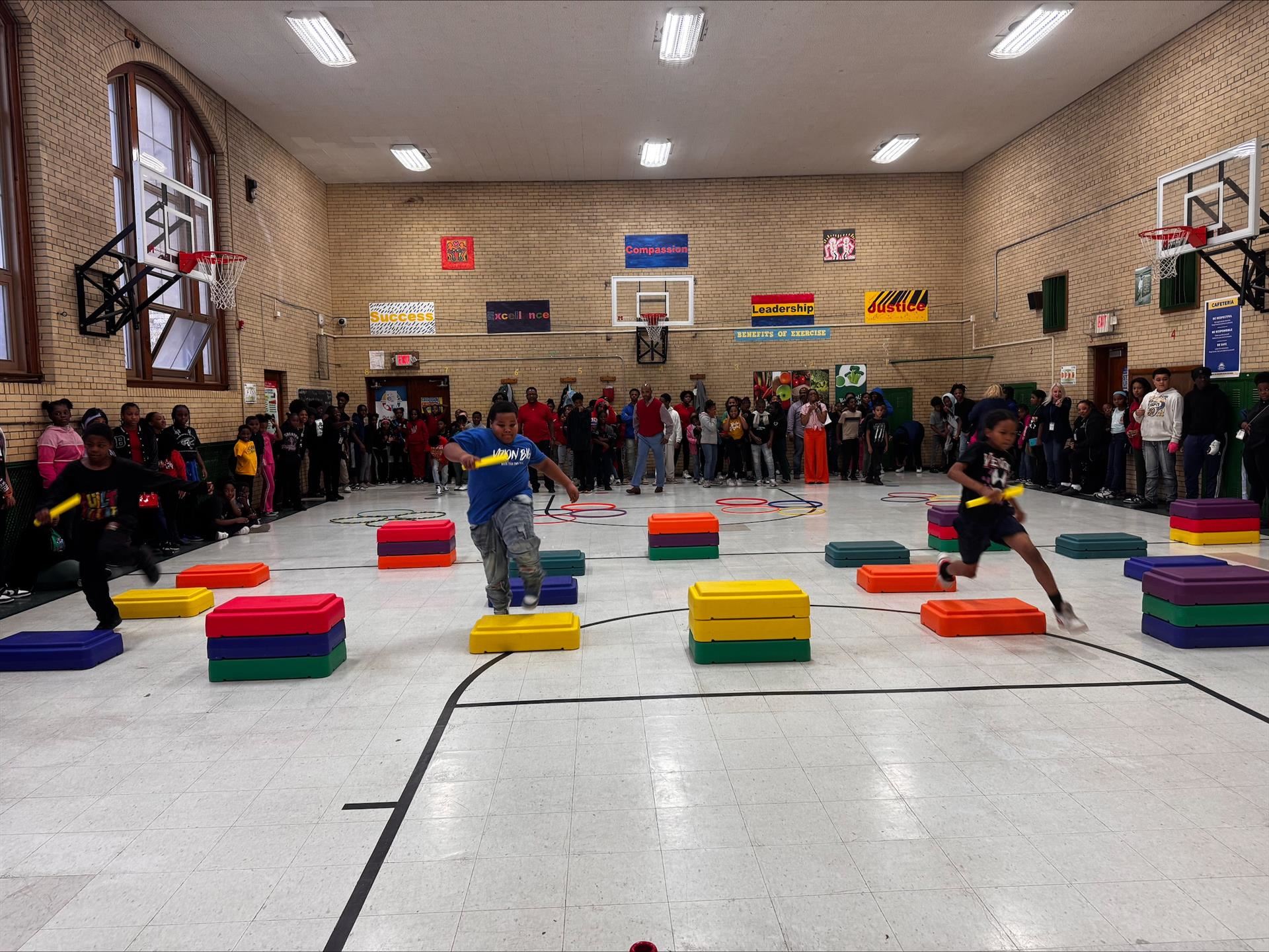 clark students compete in relay race as student spectators surround them watching on